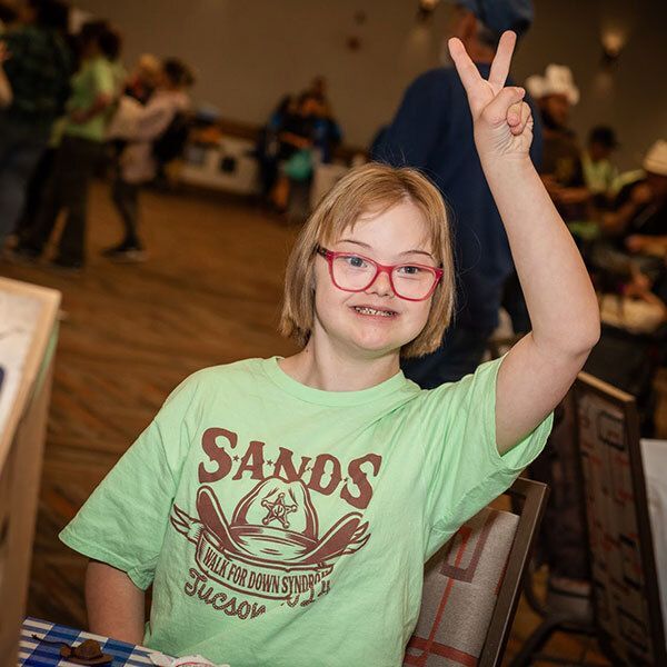Girl doing a peace sign.