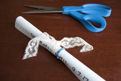 A paper message tied with ribbon for the message in a bottle project.