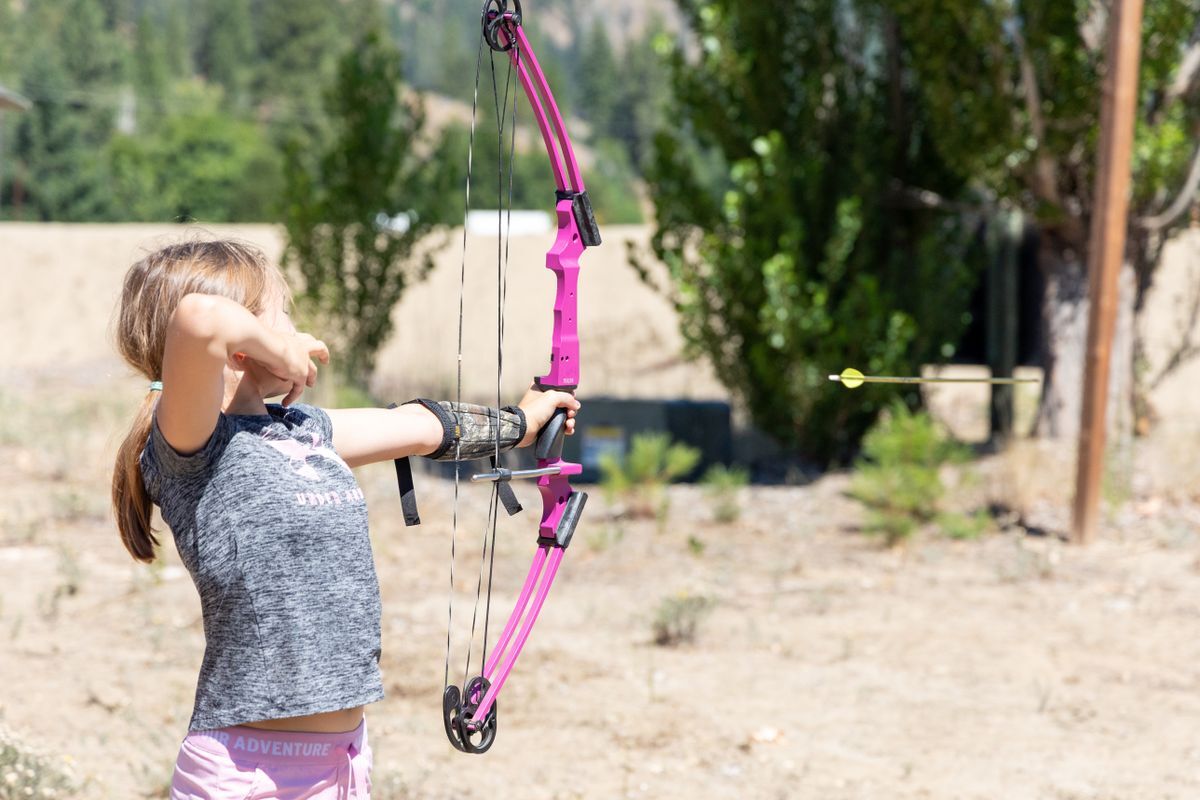 A camper lets her arrow fly towards the target at the Leavenworth National Fish Hatchery during Kids in the Wild Camp.
