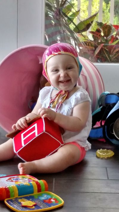 Photo of Elizabeth's one year old daughter surrounded by colorful toys