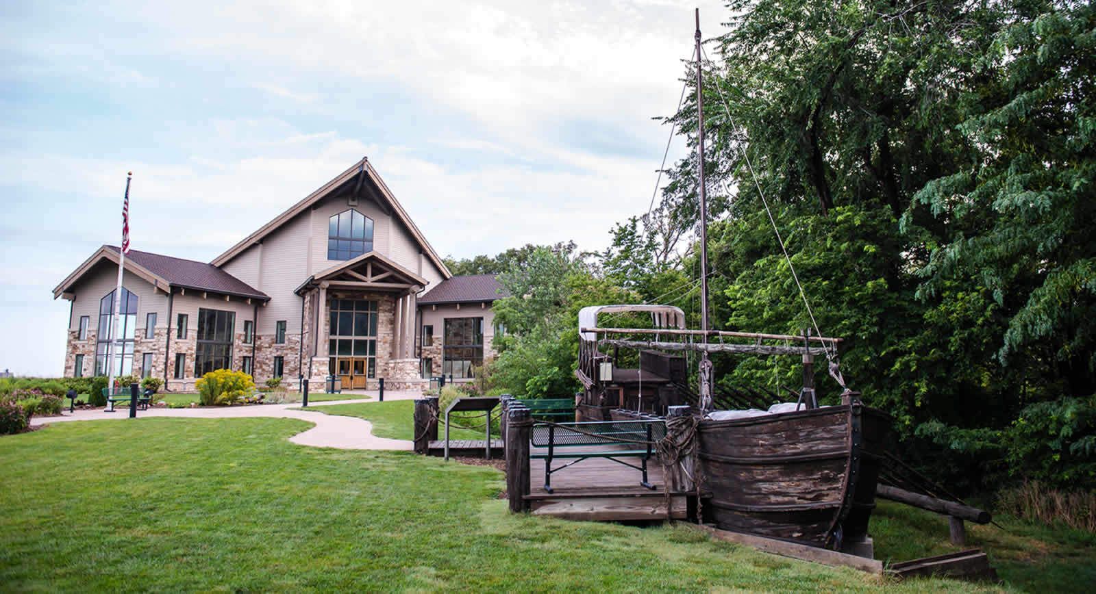 The photo shows the Lewis & Clark Visitor Center in Nebraska City along with a replica of the boat Lewis and Clark used to explore the Missouri River. 