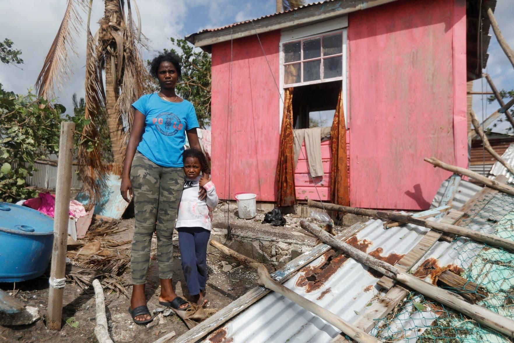 Camilla Powell 27, and daughter Destiny Ellington, 5, stand outside of their home in Alligator Pond, Jamaica, Oct. 29, 2025, after Hurricane Melissa swept through the area.