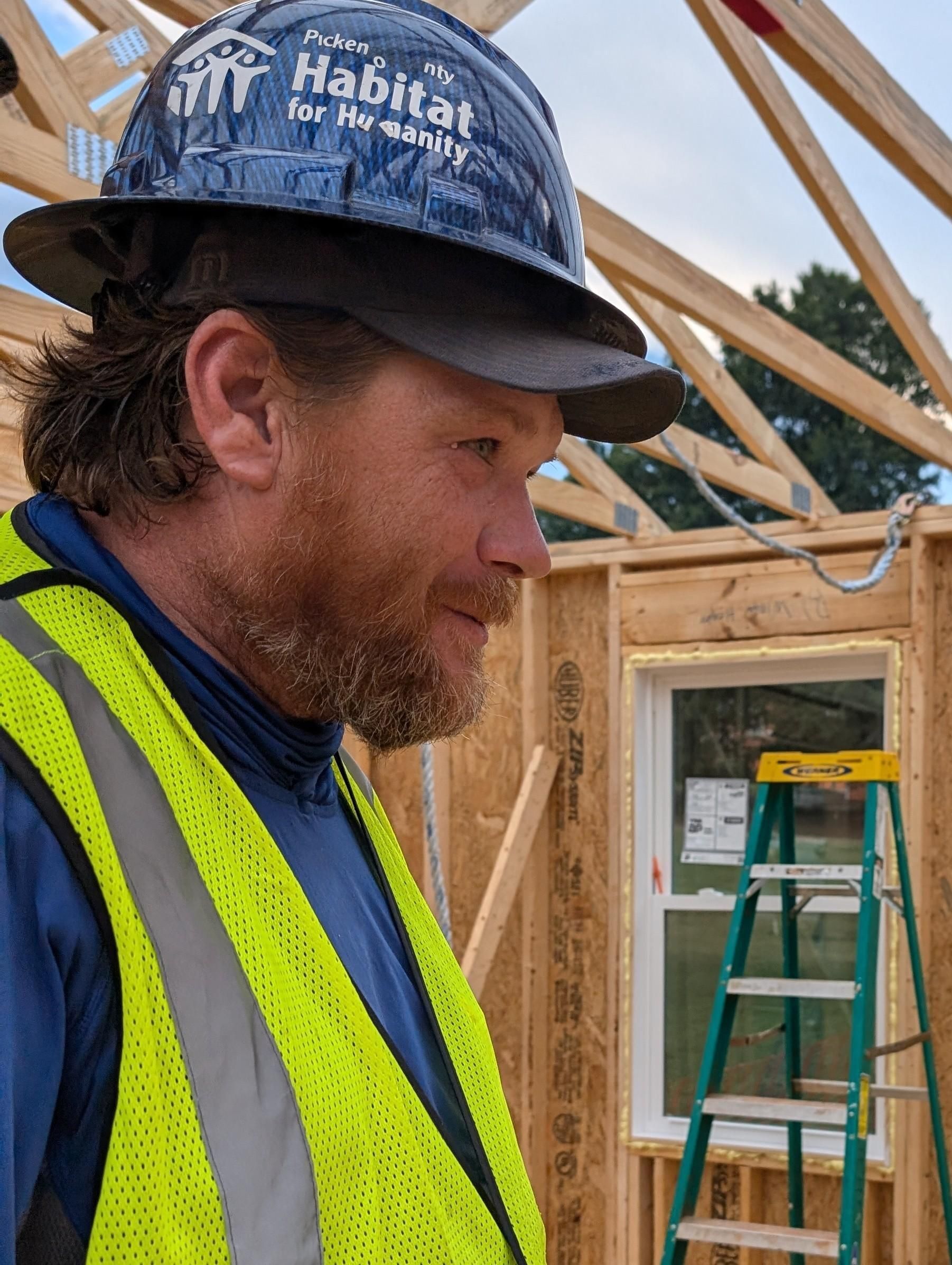 Kevin Parris, Construction Coordinator for Pickens County Habitat for Humanity, focused and determined on-site during the Homecoming Build. Wearing a safety vest and helmet, he embodies the spirit of teamwork and community service, ready to lead volunteer