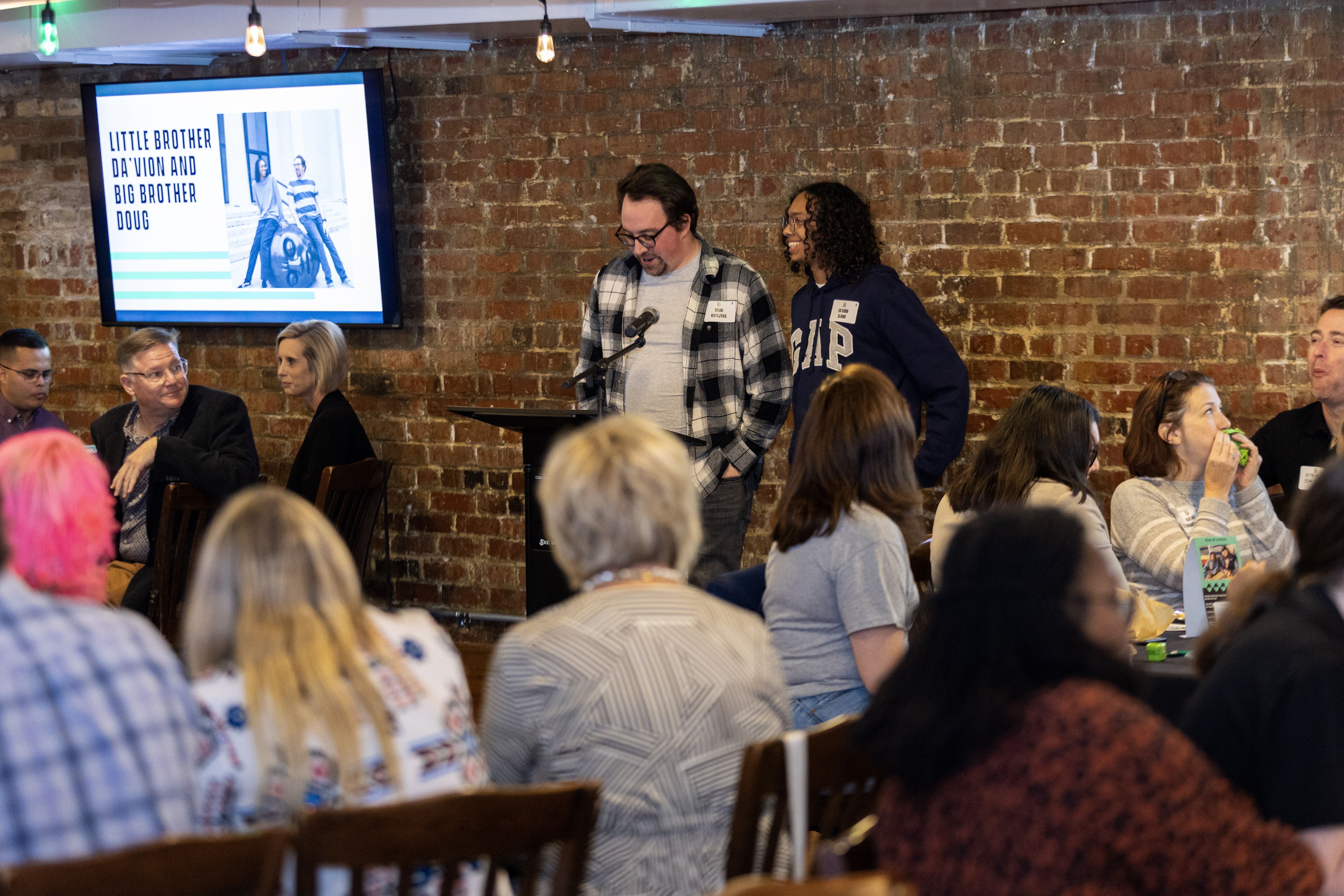 Mentor and mentee presenting in front of a group at the annual luncheon