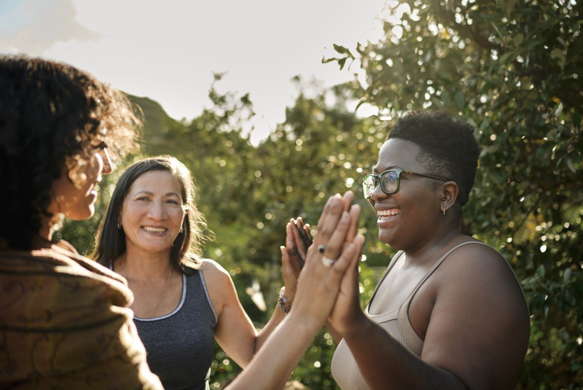 Three women in a circle giving the high five