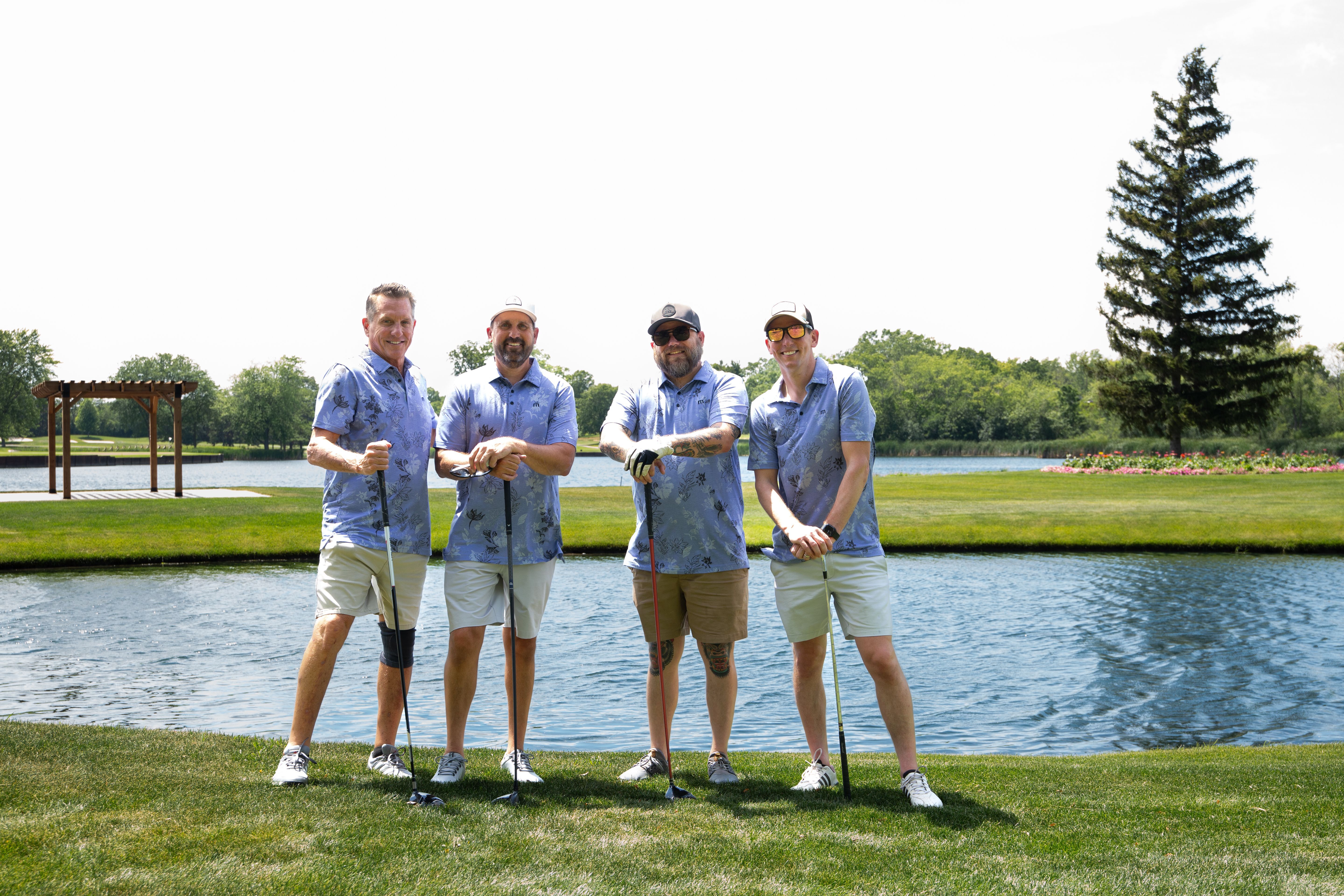 A group of 4 male golfers on a golf course