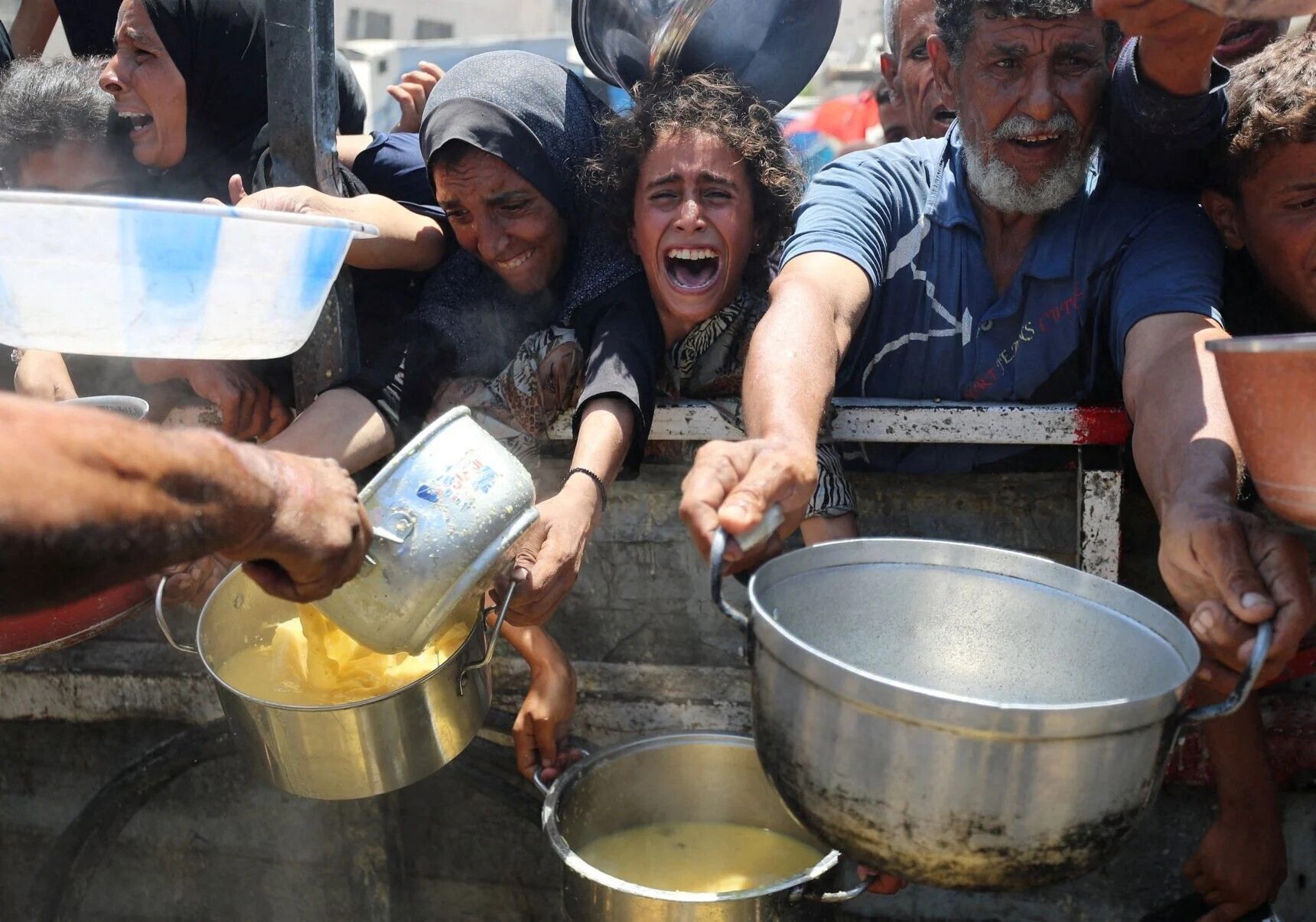 A Palestinians girl reacts as displaced people wait Aug. 2, 2025, to receive food from a charity kitchen in Gaza City, Gaza Strip, amid a hunger crisis. 