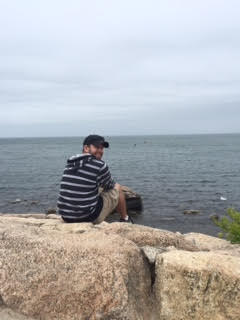 Photo of Brian Switzer on a rock overlooking the ocean