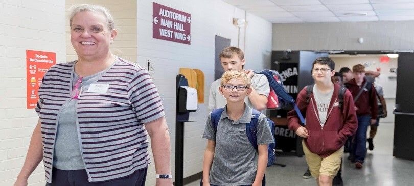 Teacher and students walking down a hallway